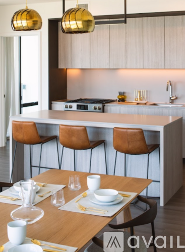 A modern kitchen with a dining table set for two.