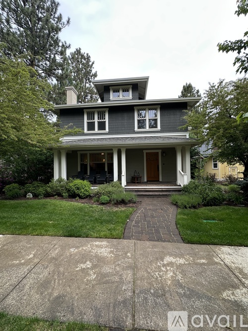 A house with a grey front and a white porch.