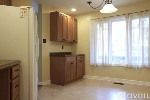 A kitchen with wooden cabinets and a white refrigerator.