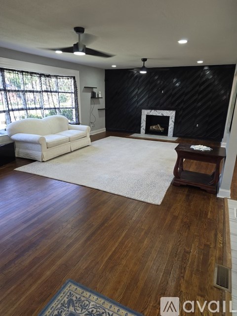 A living room with a white couch and a fireplace.