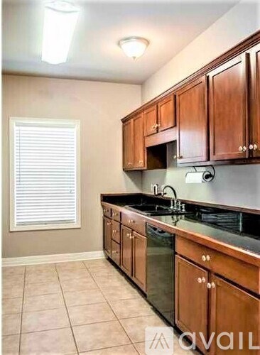 A kitchen with wooden cabinets and black countertops.