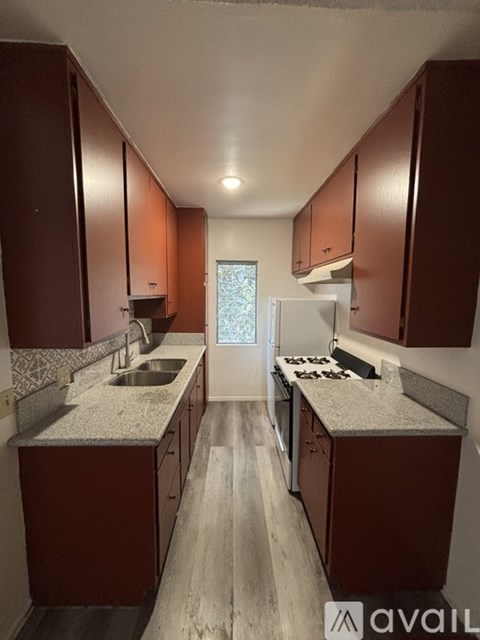 A kitchen with brown cabinets and a white refrigerator.