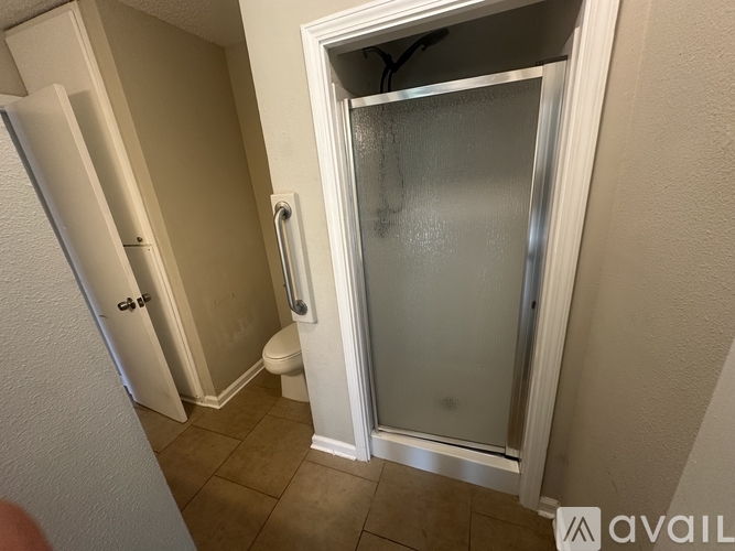 A bathroom with a toilet and a shower stall.