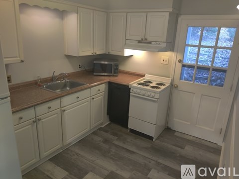 A kitchen with white cabinets and a black dishwasher.