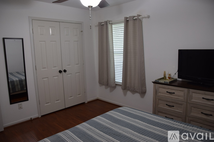 A bedroom with a bed, dresser, and mirror.
