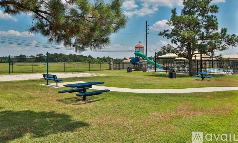 A park with a playground and picnic tables.
