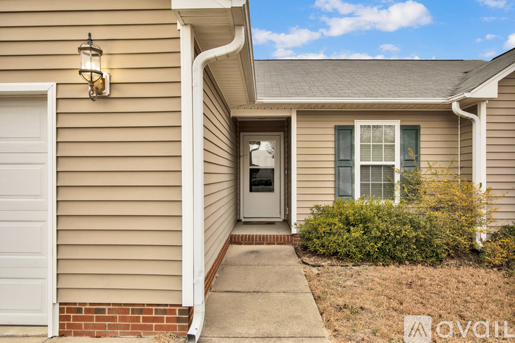 A house with a beige exterior and a white door is for sale.