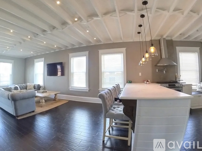 A spacious kitchen and living room with a large island in the center.