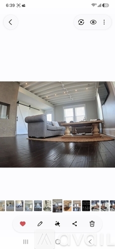 A room with a grey sofa and wooden floor.