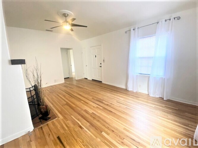A room with wooden flooring and a ceiling fan.