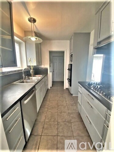 A kitchen with white cabinets and a black stove top.