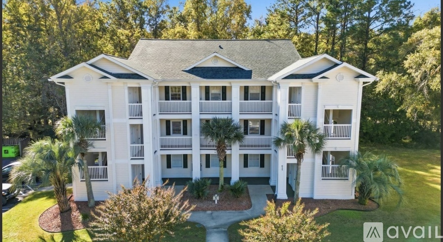 A large white house with a balcony and a green sign that says "available".