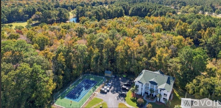 A large house with a tennis court in the backyard.