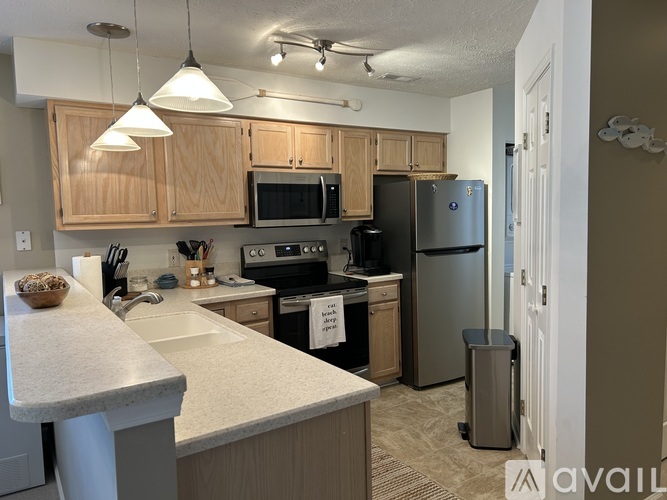 A kitchen with a white counter top and wooden cabinets.