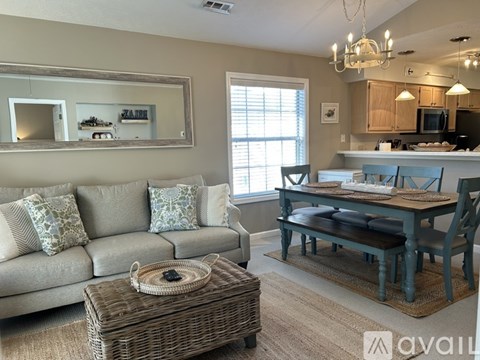A living room with a grey couch and a wicker coffee table.