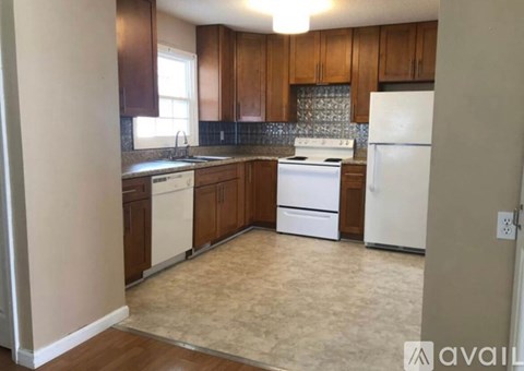 A kitchen with white appliances and wooden cabinets.