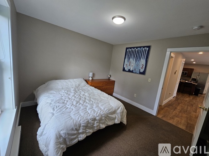 A bedroom with a large bed and a painting on the wall.