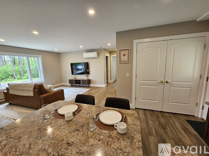 A modern dining room with a granite table set for four.