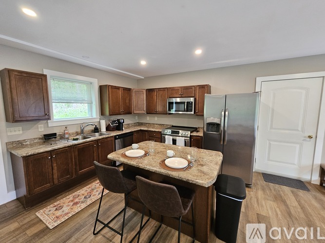 A kitchen with brown cabinets and a granite countertop.
