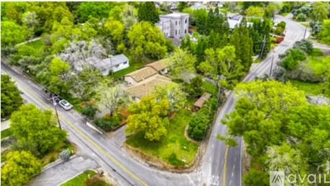 A bird's eye view of a street intersection with a white building in the background.