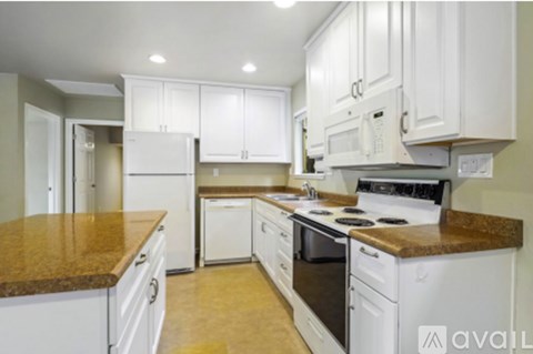 A kitchen with white cabinets and appliances.
