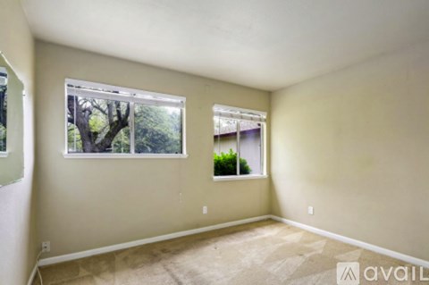 A room with a window showing trees outside.