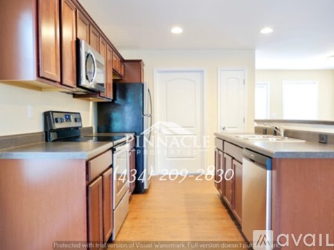 A kitchen with brown cabinets and a black fridge.