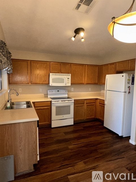 A kitchen with wooden cabinets and white appliances.