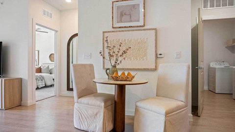 A dining room with a table and chairs.