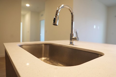 A modern kitchen sink with a chrome faucet.