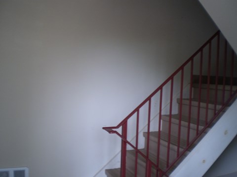 Red staircase with a metal railing.