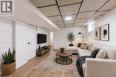 A living room with a white couch, a coffee table, and a flat screen TV.