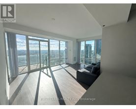 A spacious living room with a view of the cityscape outside the large windows.