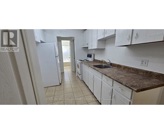 A kitchen with white cabinets and a granite countertop.