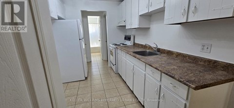 A kitchen with white cabinets and a granite countertop.