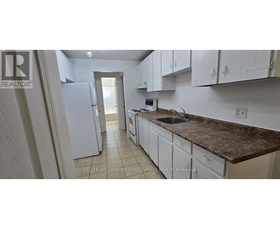 A kitchen with white cabinets and a granite countertop.