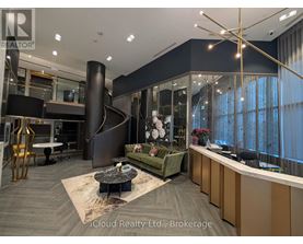 A modern office space with a reception desk and a spiral staircase.