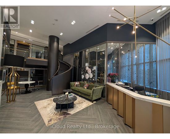 A modern office space with a reception desk and a spiral staircase.
