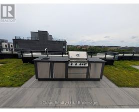 A modern outdoor kitchen setup with a grill and sink.