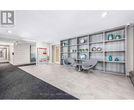 A modern living room with a grey carpet and a grey sofa.