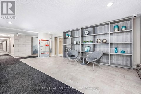 A modern living room with a grey carpet and a grey sofa.