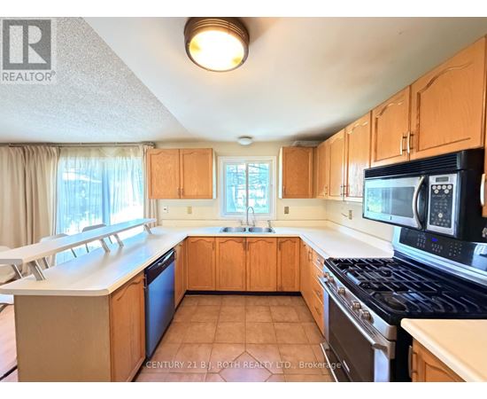 A kitchen with wooden cabinets and a black stove top oven.