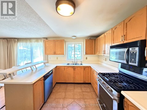 A kitchen with wooden cabinets and a black stove top oven.