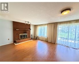 A spacious living room with a fireplace and large windows.