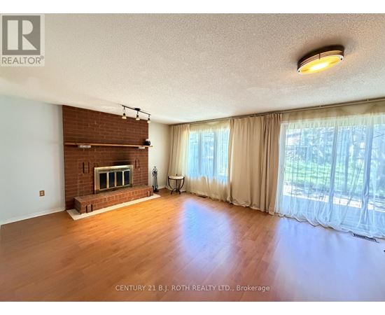 A spacious living room with a fireplace and large windows.