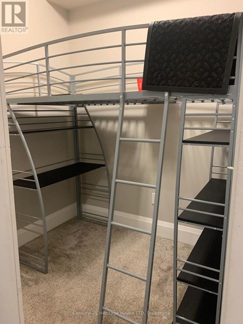 A metal bunk bed with a black mattress on top.