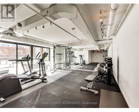 A gym with a variety of equipment including a treadmill, weights and a bench.