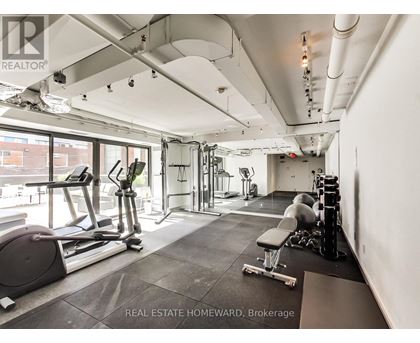 A gym with a variety of equipment including a treadmill, weights and a bench.