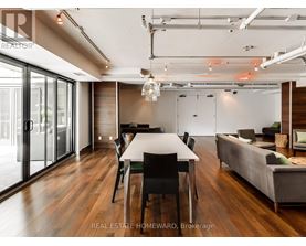 A modern dining room with a long table and chairs.