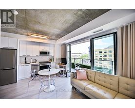 A modern kitchen with a dining table and a couch.